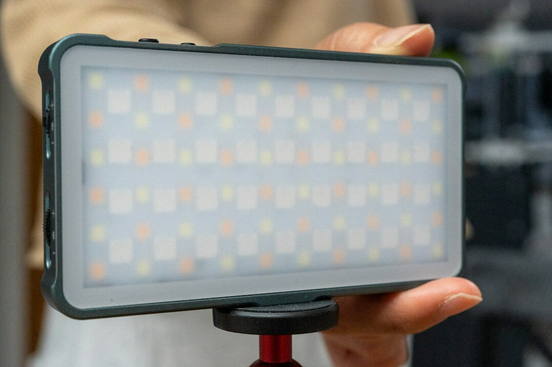 Woman videographer holding a smartphone rig with a small LED light
