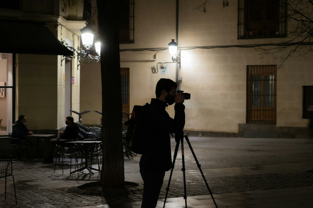 Reporter adjusting lighting while filming outdoors with a phone rig